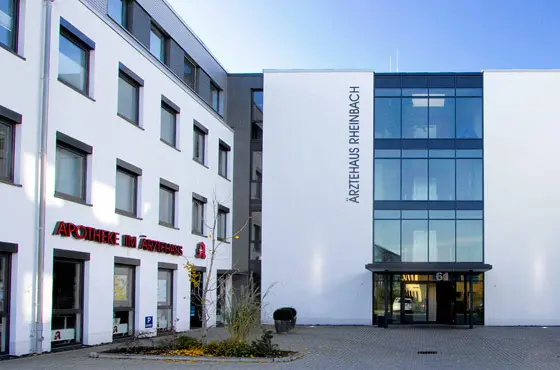 Außenansicht des Ärztehauses Rheinbach: ein heller Neubau mit großer Glasfront am Eingang.